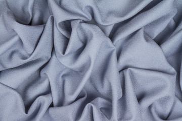 Blue woolen crumpled wrinkled fabric with waves, background crumpled tissue.