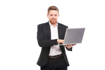 Studio portrait of young manager in suit holding open laptop