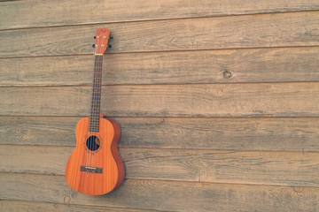 Obraz premium Ukulele Guitar over the wooden fence