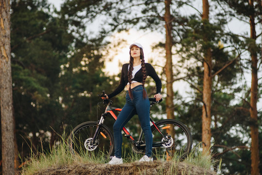 Photo of athletes cycling on the road outdoors, focused on a girl, she stopped, in trendy outfit, sneakers. Spring, healthy lifestyle, ecology, advertising HLS, place for text, social networks.