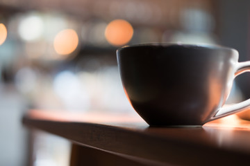 Photo of coffee cup with coaster on wooden table, blurred background. Selective focus
