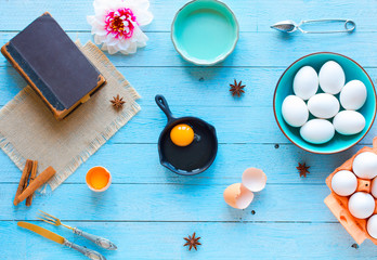 Chicken egg in light blue cup on a light blue wooden background, free space for text.