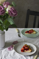 Dining table with flowers and strawberry pie, rustic style