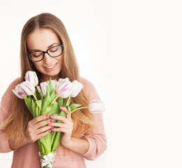 Young, beautiful girl is holding spring flowers in the studio. tulips. portrait on white background