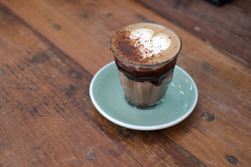 A cup of hot chocolate milk or cocoa latte art coffee on the wood desk in coffee shop , wooden background 