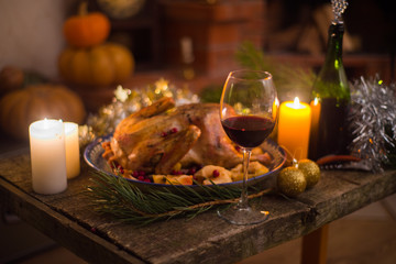 Obraz na płótnie Canvas Roasted Turkey. Thanksgiving table served with turkey, decorated with bright autumn leaves and candles. Roasted chicken, table setting. Christmas dinner