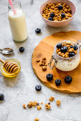Morning granola with yogurt, honey and berries on white table