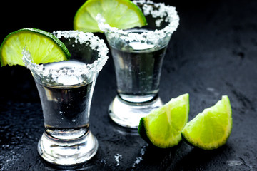 Alcohol shots with lime and salt on black background