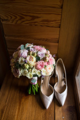 Wedding bouquet with pink peony, yellow, pink roses and greenery with elegant bridal shoes. Wedding details 