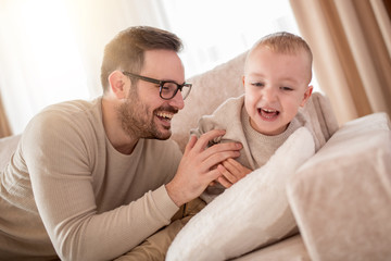 Happy father and son having fun at home