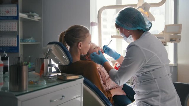 Little girl with mommy in dentist room