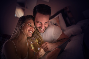 Couple watching movie in bed
