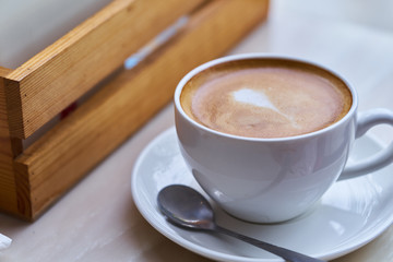 Coffee cup in coffee shop, hot Latte fresh coffee in white cup on table in cafe 
