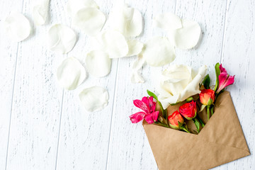 envelope and flowers on wooden background top view mock up