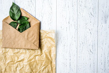 envelope and flowers on wooden background top view mock up