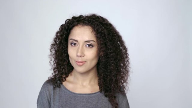 Beautiful curly female looking at camera smiling