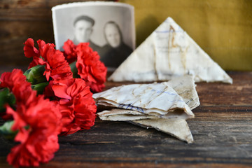 background for postcards by may 9, victory day: cap, letters, carnations and St. George ribbon Soviet icons and old photos
