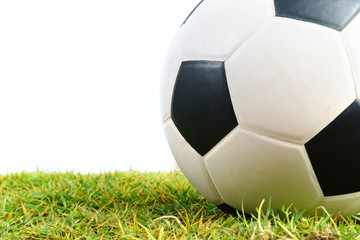 Soccer ball on green grass isolated on white background