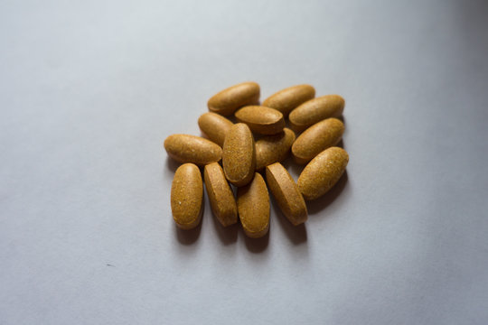 Heap of big oblong orange multivitamin tablets