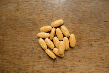 Multivitamin tablets on wooden table from above