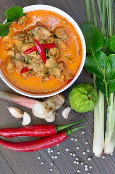 Chicken Panang curry in the white bowl and fresh spice on gray wooden background, Thai food