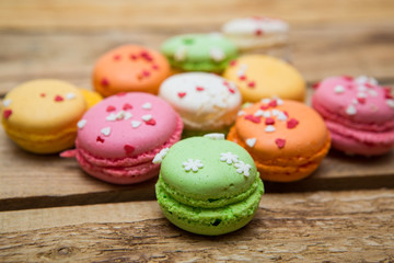 colored French macaroons on a wooden table