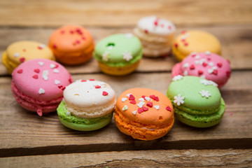 colored French macaroons on a wooden table