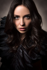 Fototapeta na wymiar Vertical fashion portrait in dark tones. Beautiful young woman in black