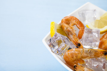 Fresh shrimp with lemon on ice