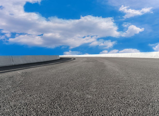 Asphalt pavements and square floor tiles under the blue sky and white clouds