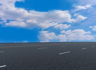 Fototapeta premium Asphalt pavements and square floor tiles under the blue sky and white clouds