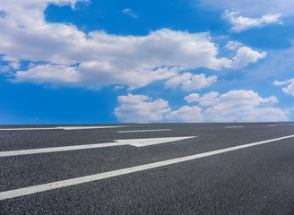 Asphalt pavements and square floor tiles under the blue sky and white clouds