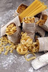 Fototapeta premium Various mix of pasta on grey rustic background. Diet and food concept.