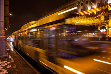 Fototapeta na wymiar Blurred bus traffic on the avenue at night in winter