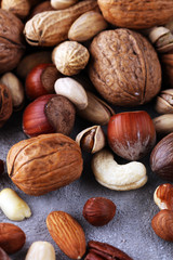 mixed nuts on grey background. Healthy food and snack. Walnut, pecan, almonds, hazelnuts and cashews.