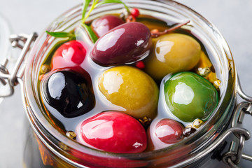 Olives assortment in glass jar with oil. Close up.