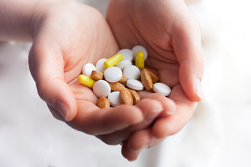 Close up view of woman's hands holding plenty of different drugs. Painkillers and antibiotics. Healthcare and medicine concept