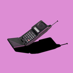 Old classic analog mobile phone nostalgia in punchy color, with aerial and microphone flip, for...