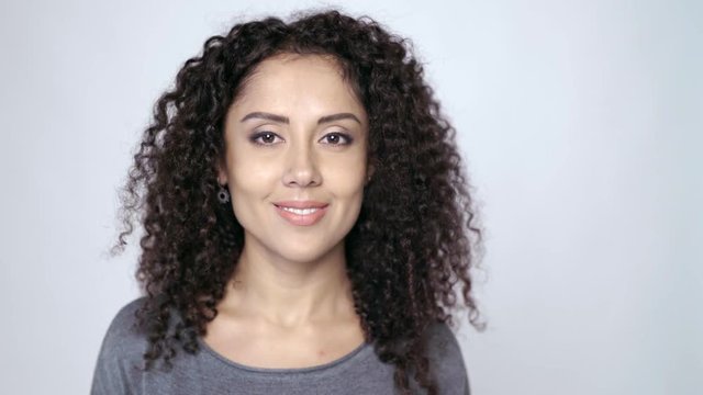 Closeup of beautiful curly female looking at camera smiling