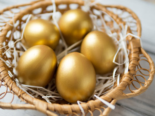 Golden eggs in a wooden wicker basket