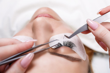 Eyelash Extension Procedure. Woman Eye with Long Eyelashes. Lashes, close up, selected focus. - 193156054