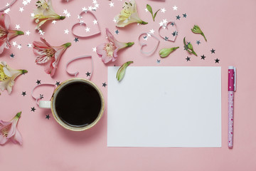 Cup of coffe and spring greeting with a pen, flower composition. top view, flat lay. place for text, copyspace