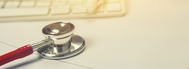 Stethoscope with clipboard and Laptop on desk,Doctor working in hospital writing a prescription, Healthcare and medical concept,test results in background,vintage color,selective focus,copy space