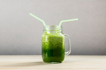 Green detox juice jar with green vegetables with copy space.