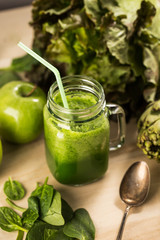 Green detox juice jar with green vegetables with old spoon