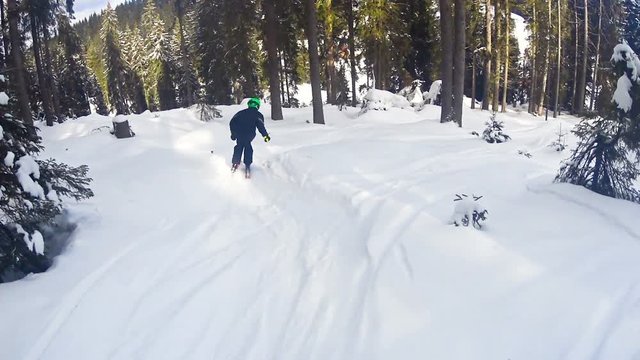 Free rider child boy skier skiing through the forest. Adrenaline sport concept.