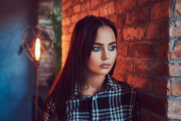 Fototapeta premium Portrait of an attractive brunette dressed in flannel shirt