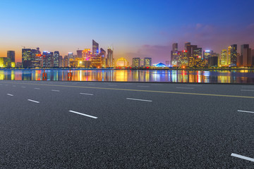 View of the skyline of Hangzhou urban architectural landscape from square floor tiles and empty asphalt pavement