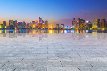 View of the skyline of Hangzhou urban architectural landscape from square floor tiles and empty asphalt pavement