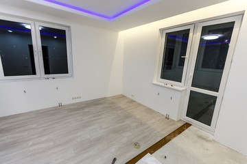 Installing light laminate floor with substrate under a laminate on white background